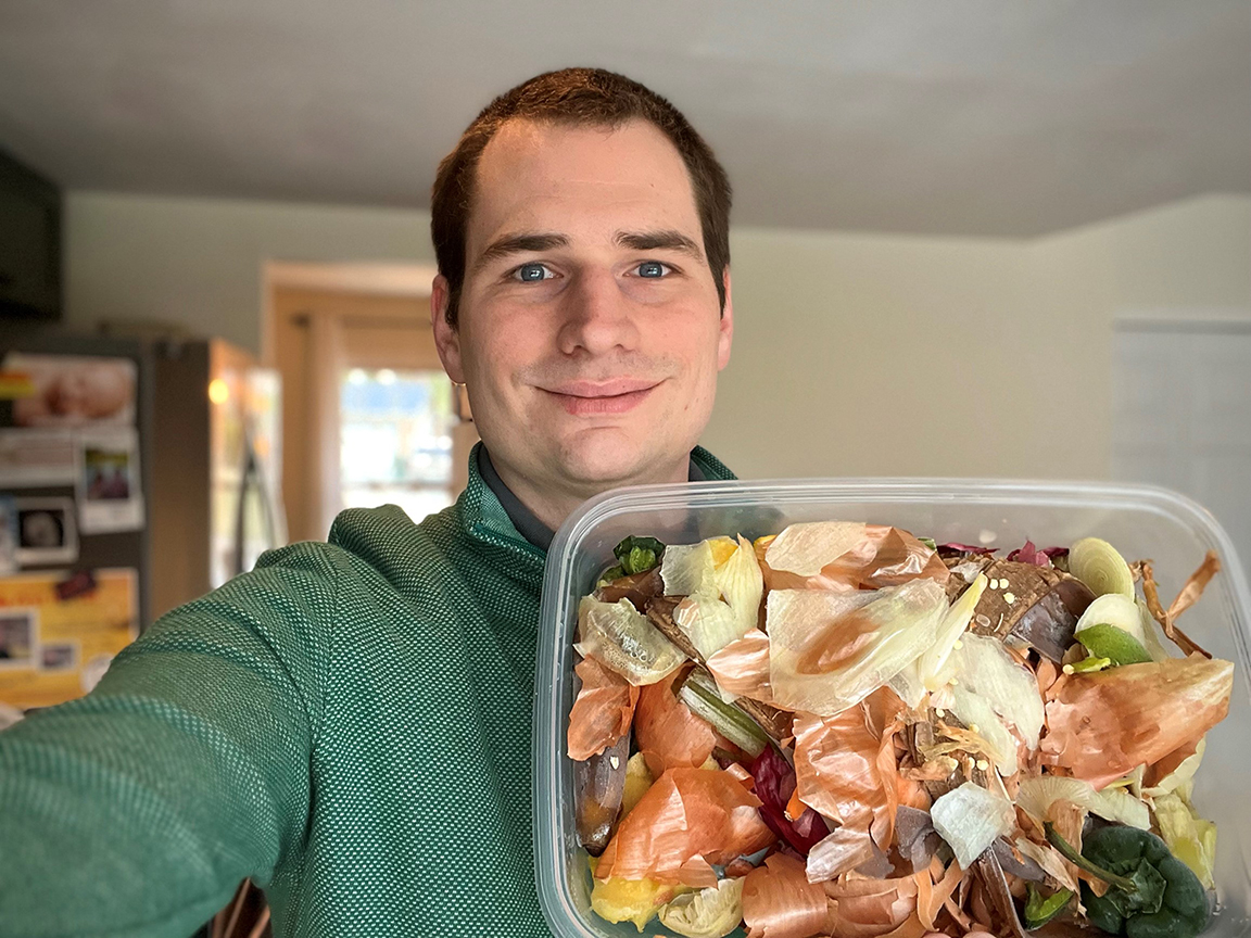 Taz Lombardo holding up a bin of compost